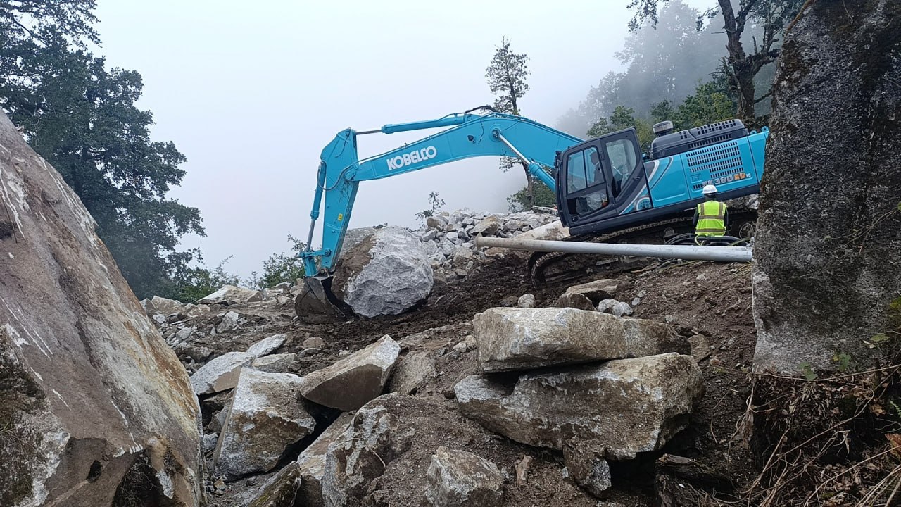Excavator and site worker during quarry development at Kailash Granite Quarry in Palung.