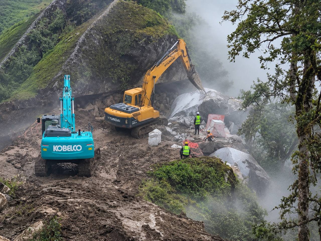 Two excavators and quarry workers beside granite rock faces in the misty hillside at Kailash Granite Quarry