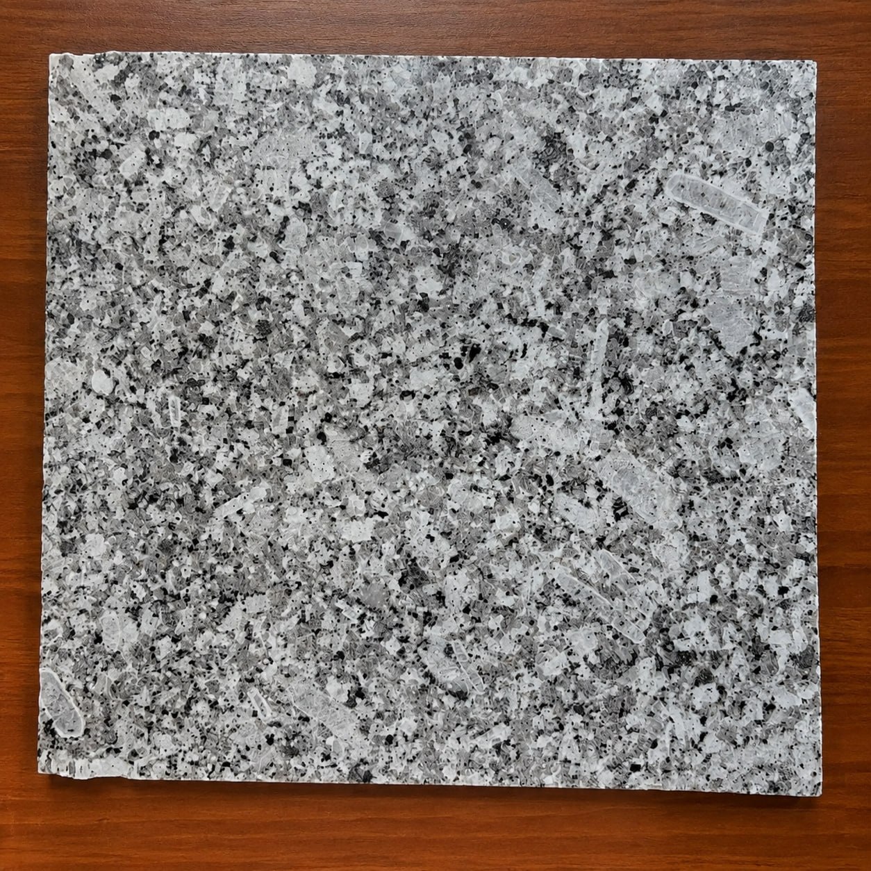 Close view of P-White granite crystalline structure and darker mineral inclusions