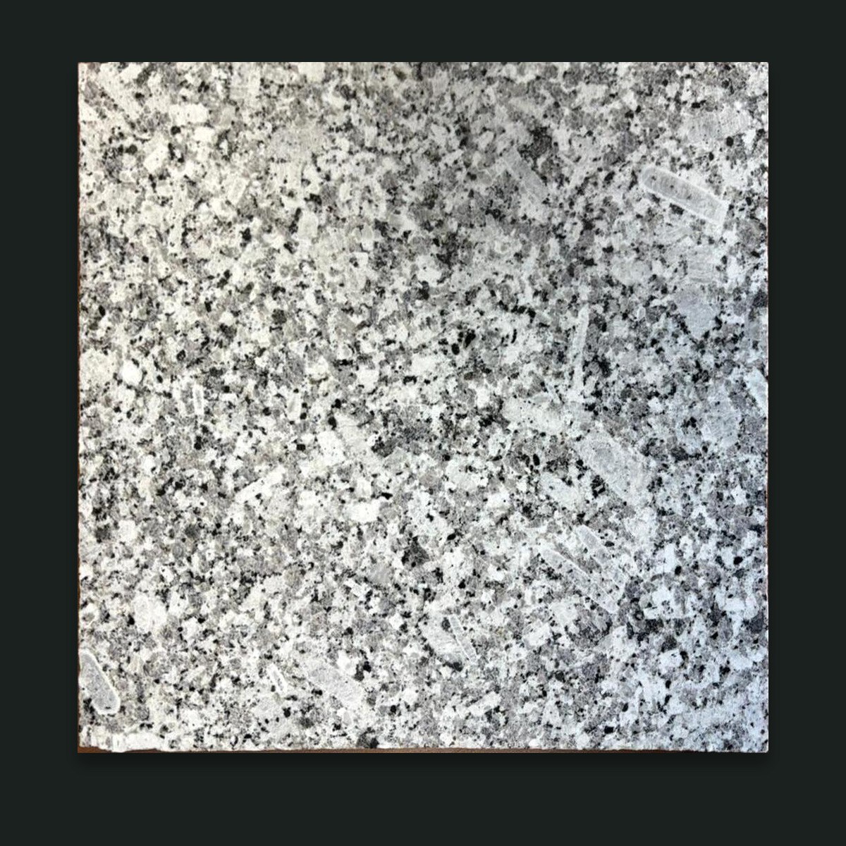 Cut P-White granite sample on graphite background
